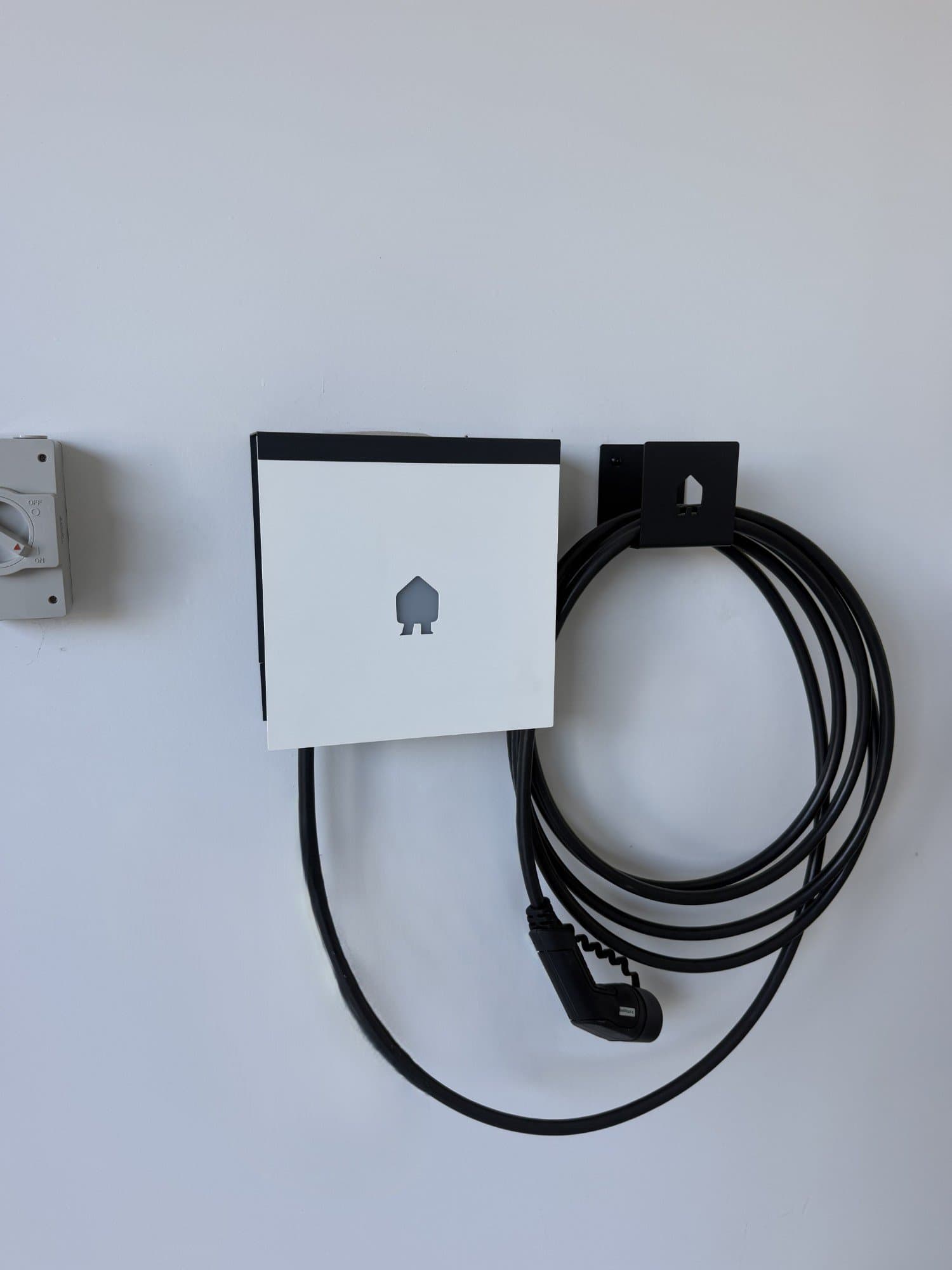 EV charger with cable neatly coiled on a wall-mounted holder