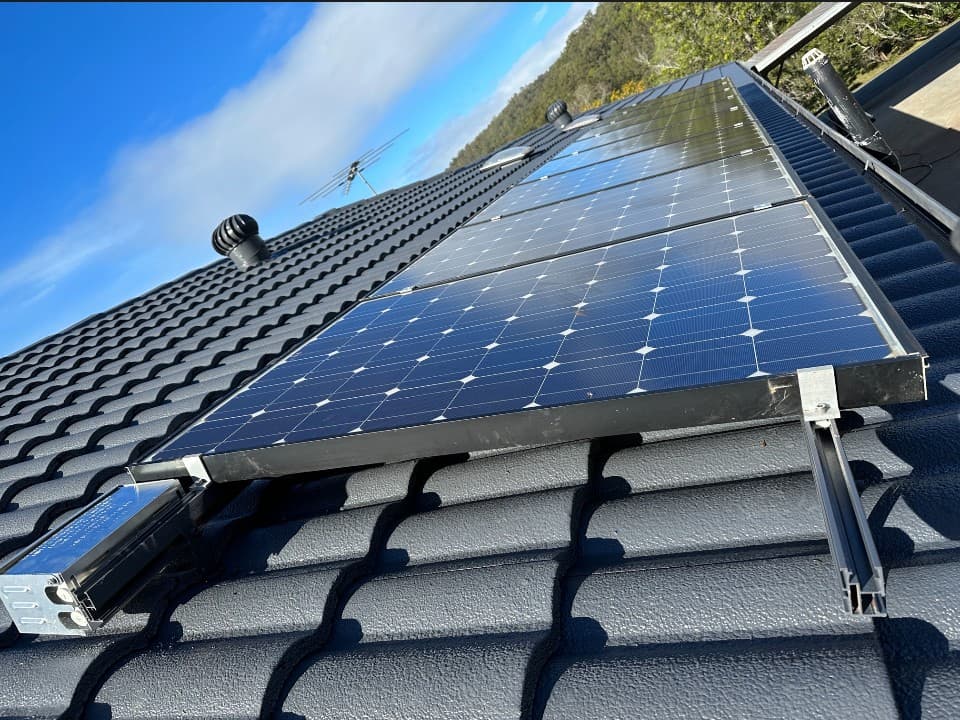 Close-up of solar panel mounting and cabling on a tile roof
